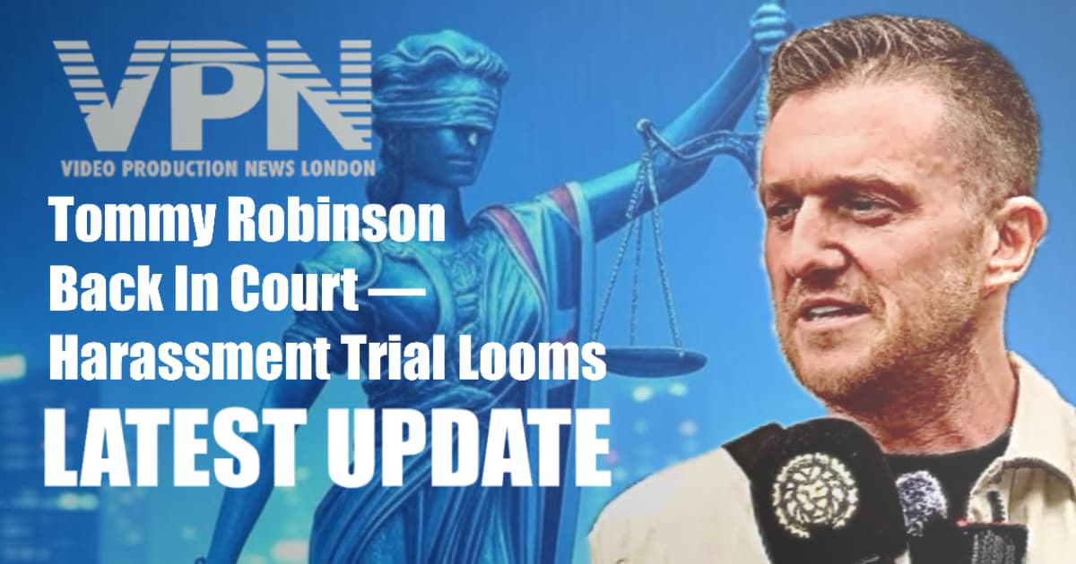 Tommy Robinson speaks to media in front of a symbolic Lady Justice statue backdrop, with bold VPN logo and “Latest Update” banner highlighting harassment trial.